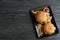 Plate with tasty burgers, french fries and sauce on wooden background, top view.