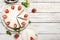 Plate with tasty cheesecake with strawberries and mint on a wooden background.