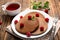 Plate with tasty chocolate pancakes, raspberries and cup of tea on wooden table