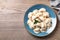 Plate of tasty cooked dumplings on wooden table, top view