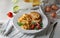 Plate with tasty omelet and toasted bread on white wooden table