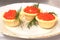 On a plate are three tartlets with red caviar. Delicious festive delicacy for the new year, Thanksgiving or other dinner. Registra