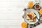 Plate with toasts, orange, jam, cream and towel on wood background, copy space