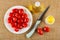 Plate with tomato cherry, bottle with vegetable oil, knife,  salt shaker on brown mat. Top view