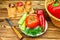 Plate with tomato, pepper, fresh produce, vegetables, wicker basket and knife on the wooden table.