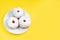 Plate with traditional Jewish dessert Sufganiyot on yellow background. Celebrating religious Judaism holiday. Donuts