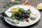 Plate of traditional pelmeni, ravioli or dumplings black color with fish stuffing and caviar, Restaurant menu, dieting, cookbook