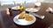 Plate of traditional quesadillas and cup of black beans on brown table