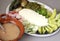 Plate of typical Mexican snack with cheese, nopales, chili peppers, avocado accompanied by a clay plate with pot beans