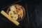 Plate of uncooked various pasta on dark table