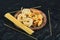 Plate of uncooked various pasta on dark table