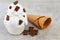 Plate of vanilla ice cream scoops, and chocolate pieces and waffle cones