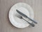 Plate and vintage cutlery on beige placemat. table set