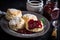 plate of warm scones, topped with scoop of strawberry jam and a dusting of powdered sugar