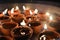 A plate is which is loaded with rose and candle on indian festival diwali deepawali with fire isolated on table