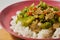 A plate of white rice with stir fried gambas or luffa gourd and sliced meatballs