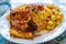 Plate of yellow rice topped with mutton meat and potatoes