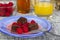 Plated chocolate brownies and raspberries on a woven table mat