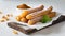 Plated of tasty churros with sugar powder on wooden board. Traditional Spanish pastry