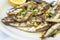 Plateful of Grilled Sardines Served with a Wedge of Lemon