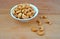 Plateful of Organic cashew and Spilled cashew on Wooden Background