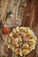 Plateful Of Oven Baked Lemon Chicken Meat With Seasoned Potato Halves And Tomato Set Alongside On Old Cracked Garden Table