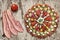 Plateful of Serbian Traditional Savory Appetizer Meze with Three Bacon Rashers and Tomato Alongside on Chipboard Background