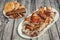 Plateful Of Spit Roasted Pork Slices With Baguette Slices And Leavened Pitta Flatbread Loaves Set On Old Pinewood Picnic Table