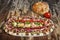 Plateful Of Traditional Serbian Appetizer Dish Meze With Pitta Bread And Tomato Set On Old Garden Table Surface