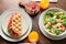 Plates with delicious bubble waffles and glasses of orange juice on wooden table