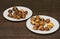 Plates filled with baked edible chestnuts on a wooden surface