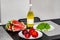 Plates with fruits and a bottle of yellow drink stand on a table against a white wall background. Peaches, grapes and watermelon