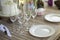 Plates and glasses on table. Table on veranda. Details of holiday. Preparing for dinner