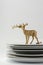 Plates stacked dishes and clean white and gold reindeer tablewa