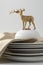 Plates stacked dishes and clean white and gold reindeer tablewa