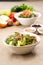 Plates of traditional Arabic salad fattouch and tabbouleh on a rustic background