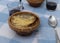 Plates of traditional French gratin onion soup on a rustic table with blue squared tablecloth, spoons and ceramic plates with