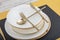 Plates and utensils, Plate, Bowl and golden cutlery on dining table, side view. Modern craft ceramic tableware, cutlery on the