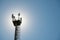 Platform on a cell phone mast with fences and transmitters, against the backdrop of the sun on a summer day