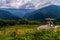 Platform with a lift wheel with people standing on it. With a beautiful view of the mountain slopes covered with green