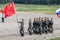 A platoon of soldiers of the Chinese army with the flag of the people`s Republic of China marching in a parade step