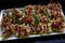 A platter of appetizing hors d oeuvres with colorful skewers on a black background