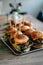 Platter filled with a variety of freshly-made hamburgers, garnished with toothpicks