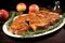 platter of pork chops topped with apple sauce next to rosemary sprigs