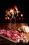 Platter of serrano jamon Cured Meat with cozy fireplace and wine