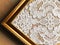 Plauener spitze (Plauen lace) handmade doily on wooden background in the golden frame