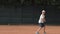 Play in tennis, determined sportsman teen boy concentrating and focusing on game and racket beats ball on red court