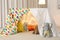 Play tent decorated with festive lights in modern child`s room