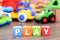 Play word from colorful cubes with many toys on background