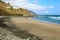 Playa de Almaciga beautiful beach with black sand with the village of Almaciga on the hill, Tenerife, Spain